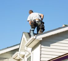 Worker installing new roof on home